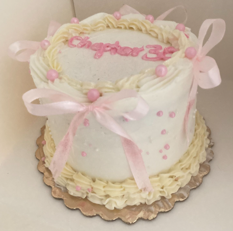 Elegant Chapter 30 celebration cake with pink ribbons and ruffled buttercream